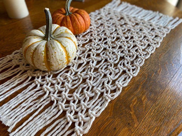 two pumpkins sitting on top of a table next to a white doily rug