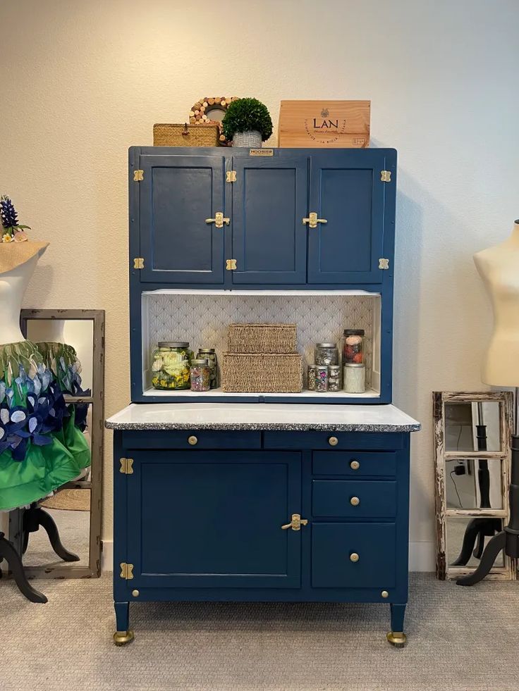 an antique blue cabinet with marble top and brass handles is displayed in a showroom