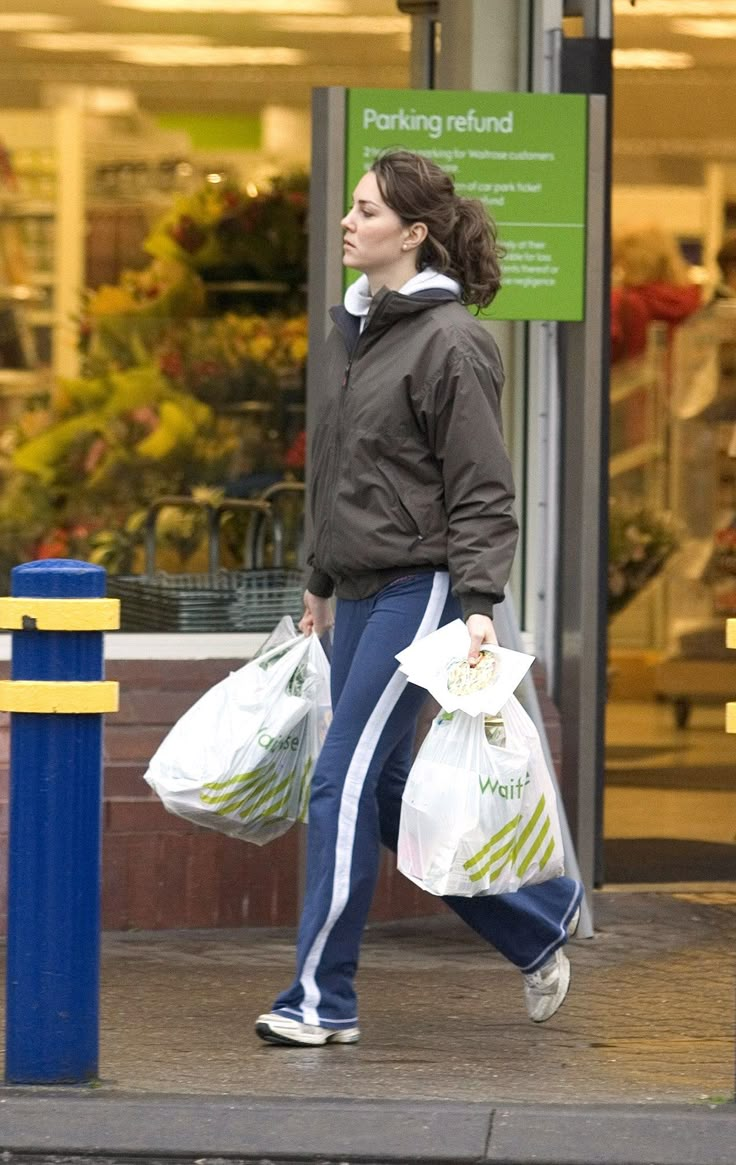 a woman is walking down the street carrying shopping bags