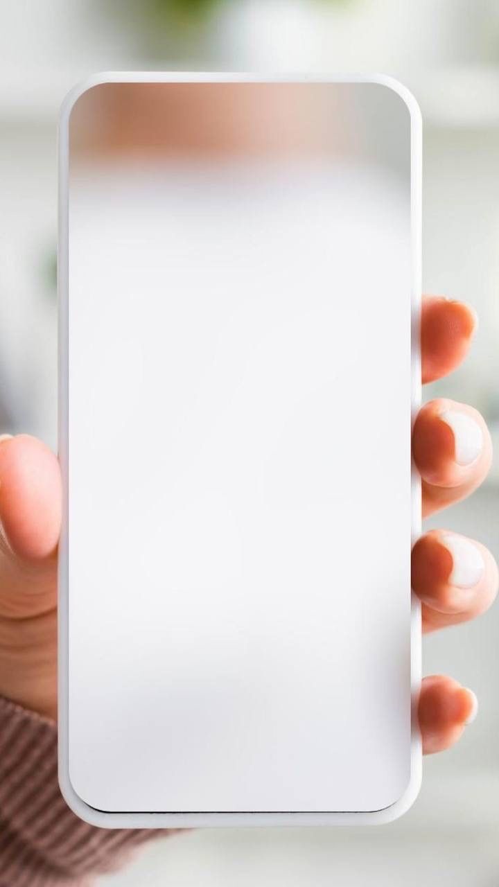 a person holding up a white square object in their hand