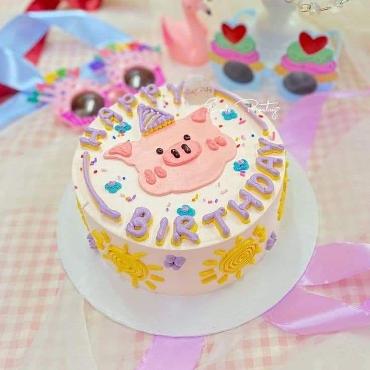 there is a birthday cake with a pig on it and other decorations around the cake