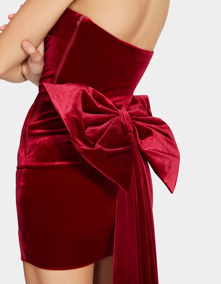 Get ready to dance the night away in the CLAIRE MINI DRESS. This formal red velvet mini dress features a removable oversized bow train that adds a touch of elegance and playfulness for any event. Materials: 65% Rayon, 30% Nylon, 5% Spandex Removable bow & dress train Care instructions: Hand wash cold Model is 5ft 10in and is wearing a size small Measurements (inches): SIZE BUST WAIST HIP S 30" 26" 32" M 32" 28" 34" L 34" 30" 36" XL 36" 32" 38" Imported Red Velvet Cocktail Dress, Christmas Bow Dress, Red Velvet Dress For Prom, Holiday Velvet Mini Dress For Cocktail Events, Holiday Velvet Mini Dress For Evening, Holiday Evening Velvet Mini Dress, Red Evening Dress With Bow Tie Back, Holiday Prom Dress With Bow Detail, Holiday Dresses With Bow For Prom