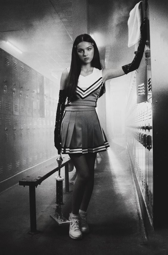 a woman in a short skirt is standing near lockers