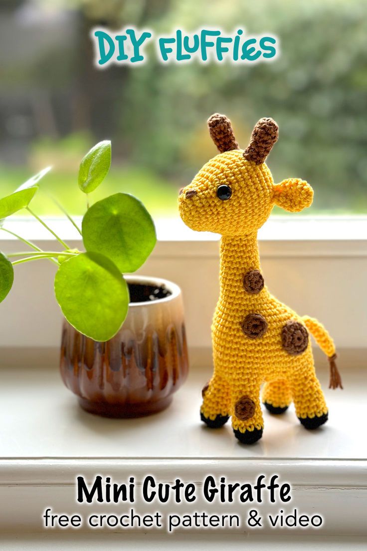 a crocheted giraffe next to a potted plant on a window sill