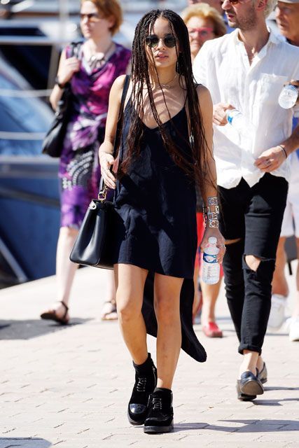 a woman with dreadlocks walking down the street