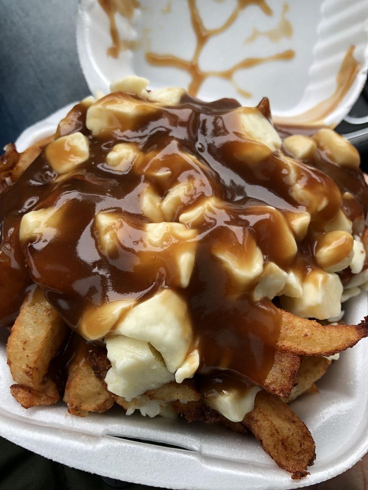 a white plate topped with waffle fries covered in caramel sauce and melted marshmallows