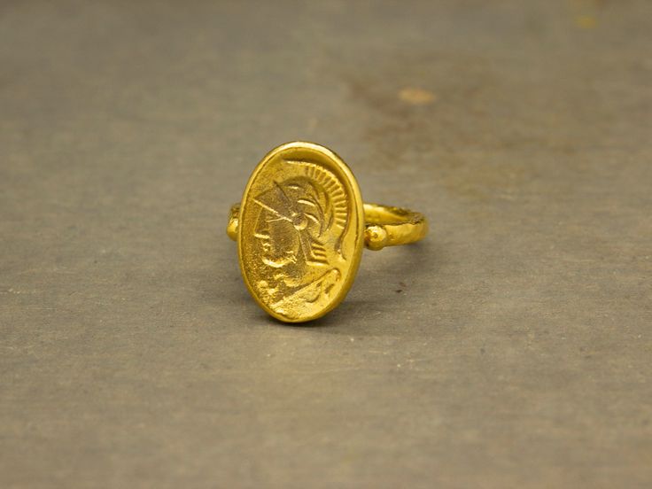 Ancient Art Soldier Signed Coin Ring made 24k gold plated 925 sterling silver and used Reproduction Bronze Coin. Our shop offer free ring sizing. Handcrafted hammered full round ring band size measures 2 mm in width and 24k gold plated bronze coin 16.5x12 mm. Metal : 925 Sterling Silver Band Width : 2 mm Coin : Reproduction Bronze Coin Coin Size : 16.5x12 mm Ring Weight : 4.84 grams Ring Size : US 6 (The size you want is made for free). (We used the US standard sizing) **Custom Orders is Made** Ancient Style Collectible Yellow Gold Rings, Ancient Gold Collectible Rings, Antique Hand-forged Gold Rings, Ancient Style Yellow Gold Signet Ring Gift, Gold Ancient Style Signet Ring For Ceremonial Use, Ancient Style Yellow Gold Rings As Gift, Ancient Style Hand Forged Gold Jewelry, Ancient Oval Gold Rings, Gold Engraved Open Ring Collectible