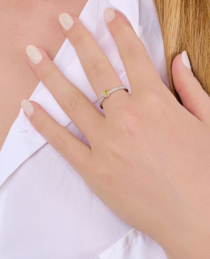 a woman's hand with a diamond ring on her left wrist, wearing a white shirt