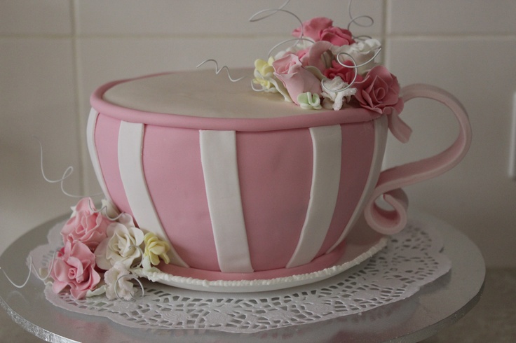 a pink and white striped cake with flowers on top