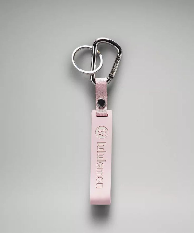 a pink keychain with the word queen on it is hanging from a metal hook