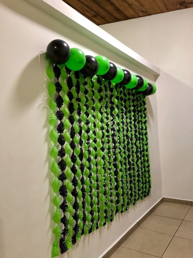 green and black balloons are hanging on the wall