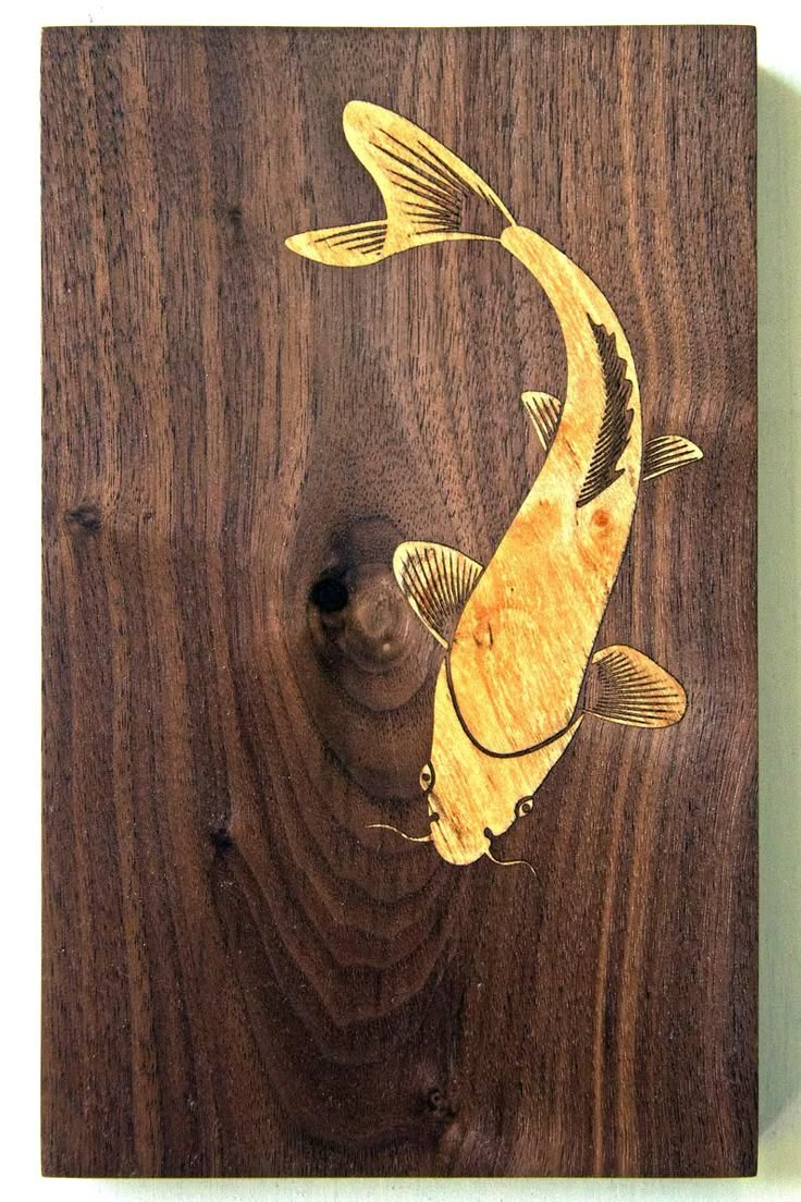 a wooden plaque with a fish carved on it