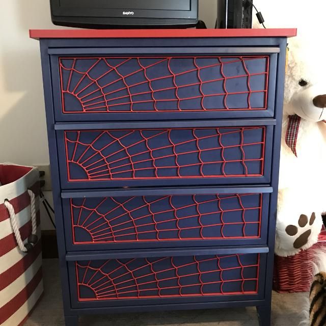 a red and blue dresser with spider web on it