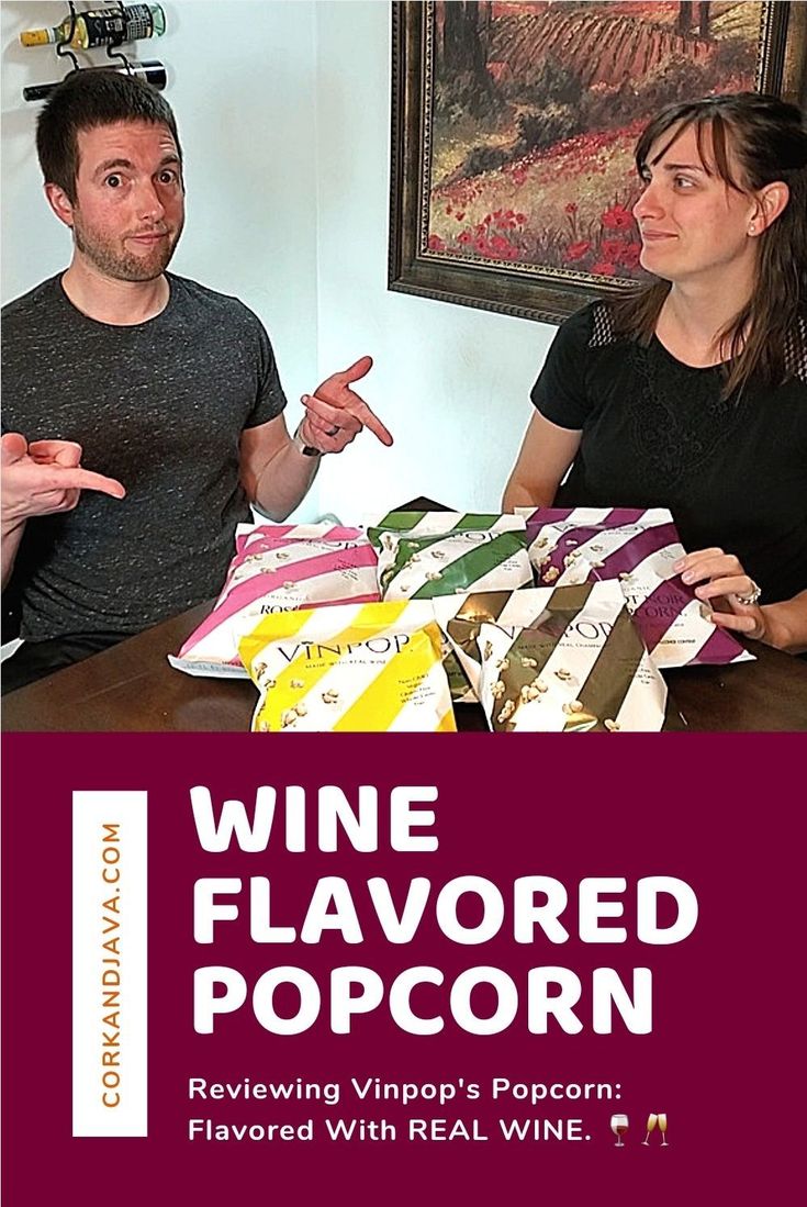 two people sitting at a table in front of wine bags with the words wine flavored popcorn written on them