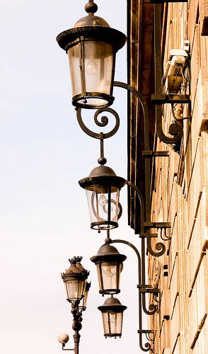 an old fashioned street light hanging off the side of a building