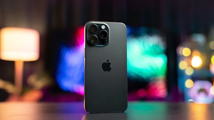 an iphone sitting on top of a table in front of a colorful light display behind it