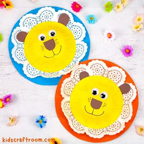 two paper plates with faces on them and flowers in the background, one has a lion's head