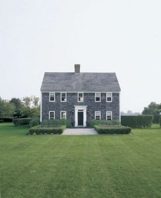 a large house sitting on top of a lush green field