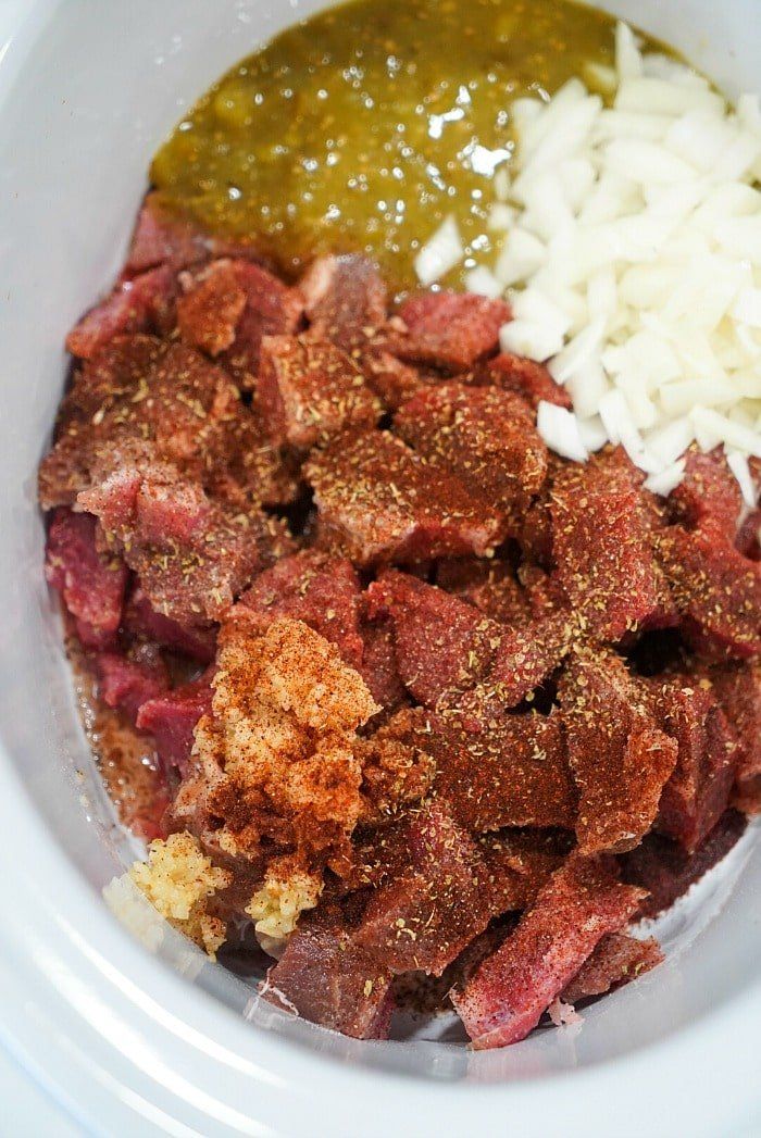 meat, rice and seasoning in a white bowl