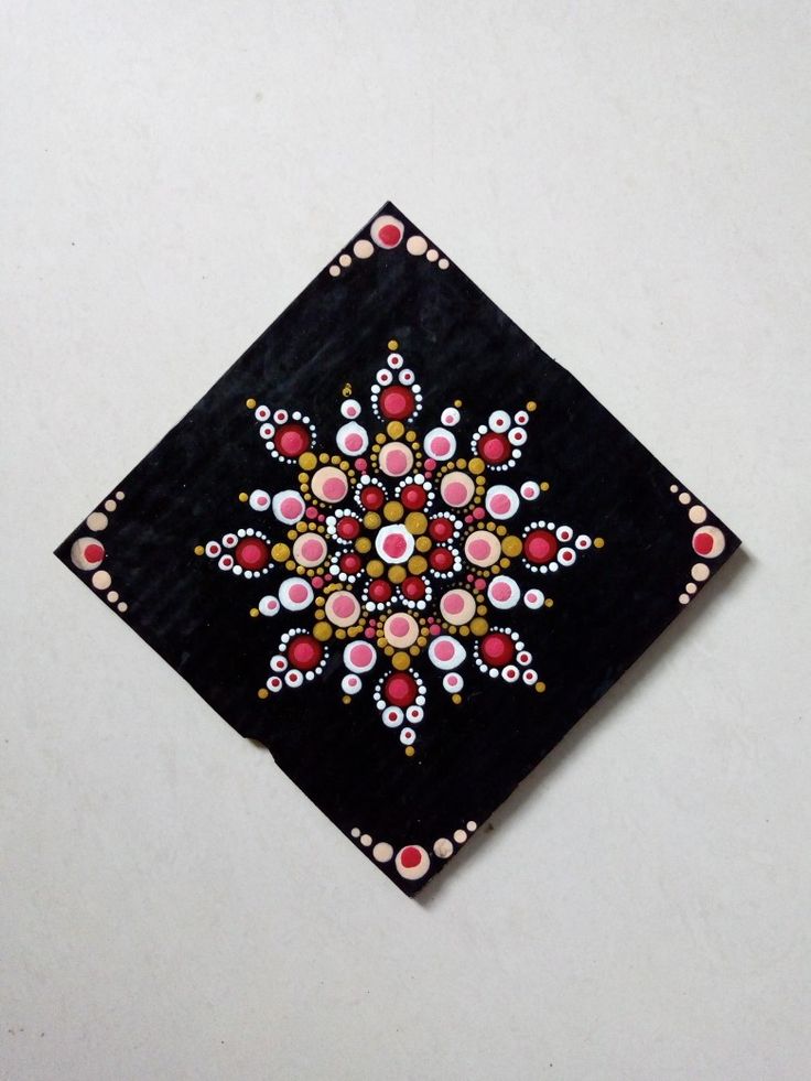 a black square with red, yellow and pink designs on the edges is shown in front of a white background