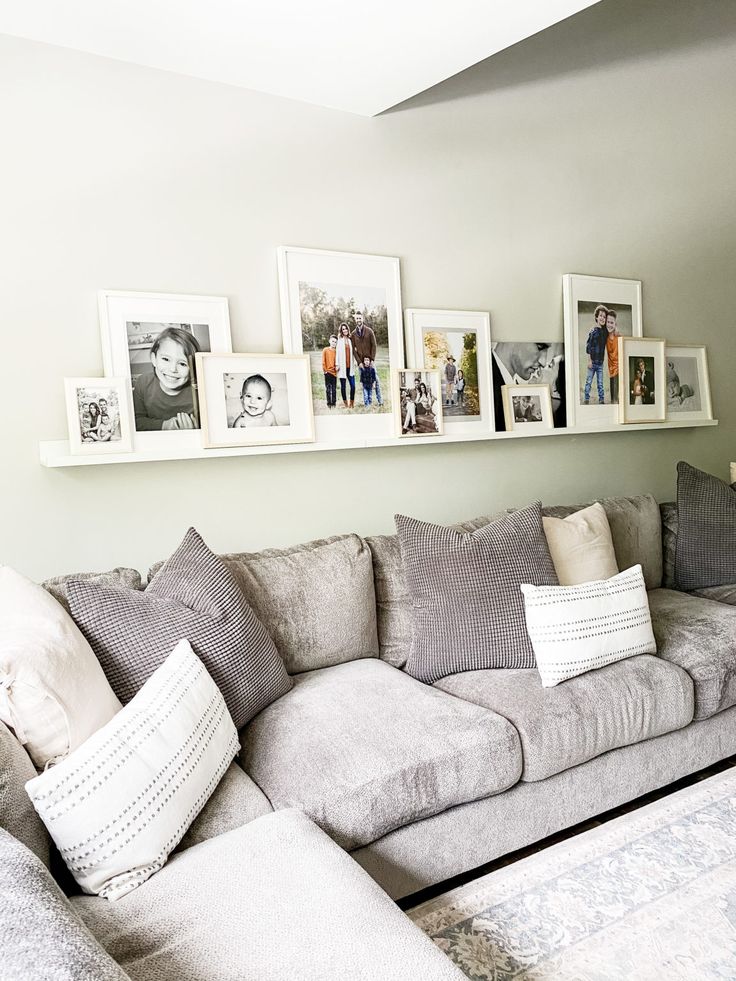 a living room filled with lots of furniture and pictures on the wall above it's couch