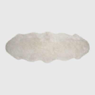 a white sheepskin rug on a gray background