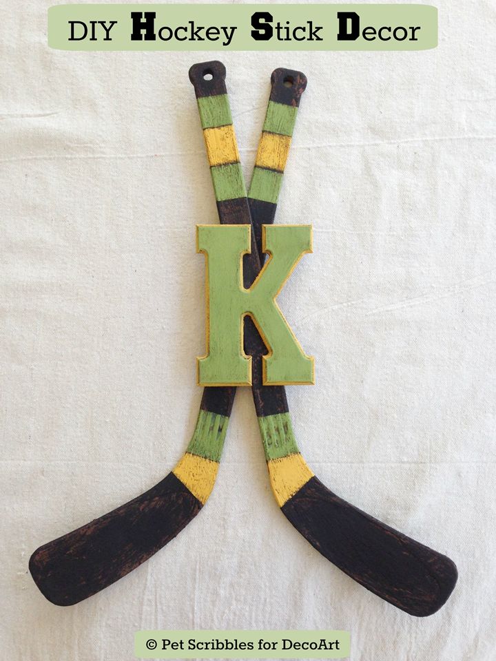 the letter k is made out of wood and has two hockey sticks attached to it