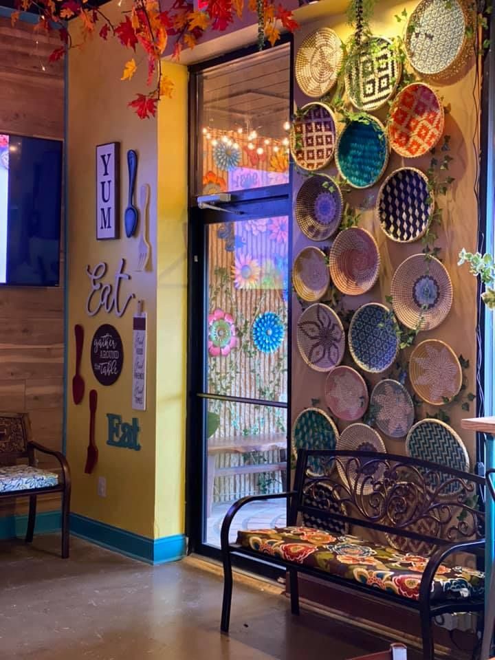 a room filled with lots of colorful plates hanging from the ceiling and chairs in front of it