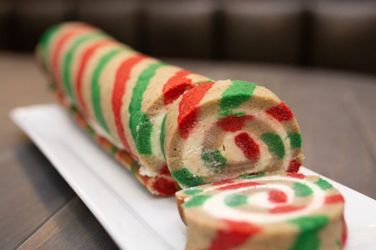 a candy roll is on a white plate with red, green and orange swirls