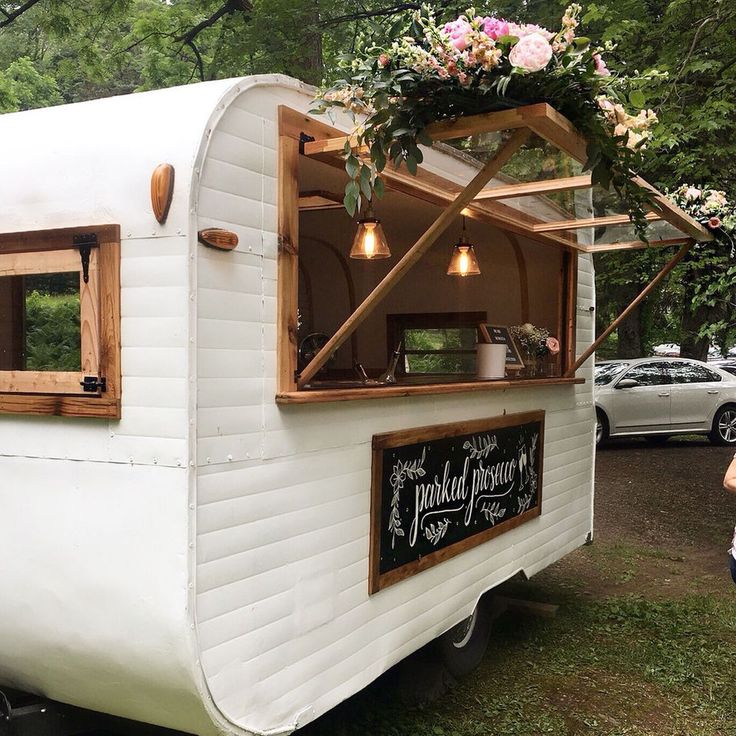 an old trailer converted into a mobile home with flowers growing out of the top window