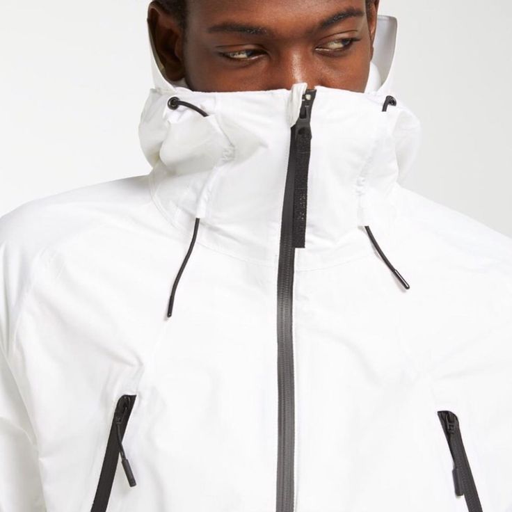 Outer Is 100% Recycled Polyester With A Two-Layer Dryvent Water-Repellent Coating Lining Is Water-Repellent Nylon Thermore Thermal Booster Insulation Waterproof Zip Chest Pockets Sleeve Pocket And Internal Phone Pocket With Headphone Port Underarm Ventilation Modern Waterproof Outerwear For Outdoor Activities, Technical White Track Jacket For Outdoor, White Technical Track Jacket For Outdoor, White Nylon Windbreaker With Detachable Hood, White Outerwear With Detachable Hood For Outdoors, White Techwear Outerwear With Detachable Hood, Modern Windproof Windbreaker For Outdoors, White Waterproof Outerwear For Streetwear, White Urban Nylon Outerwear