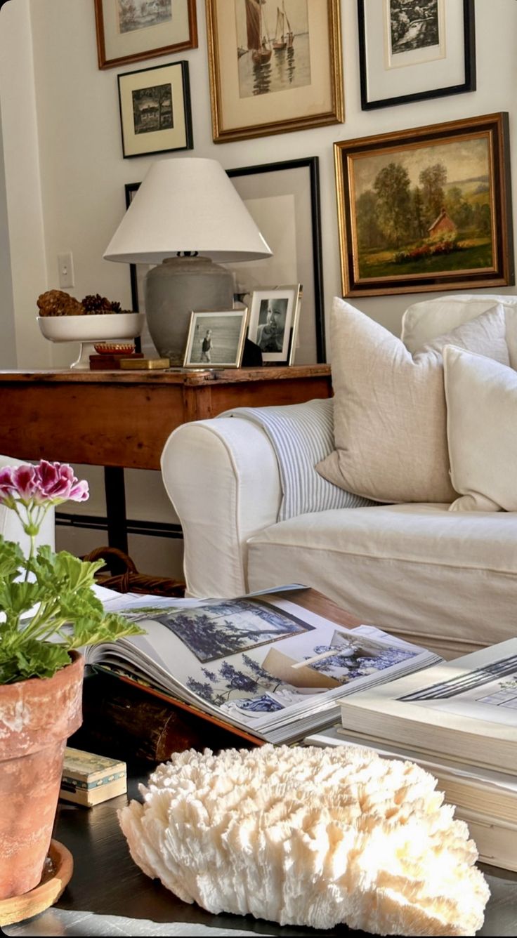 a living room filled with lots of furniture and pictures on the wall above it's coffee table