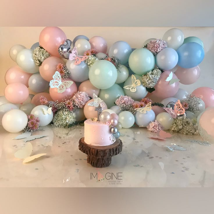 a cake surrounded by balloons and confetti