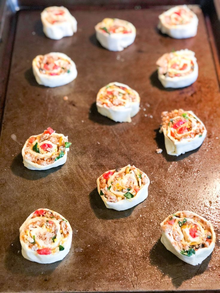 some kind of appetizer sitting on top of a baking sheet with other food items