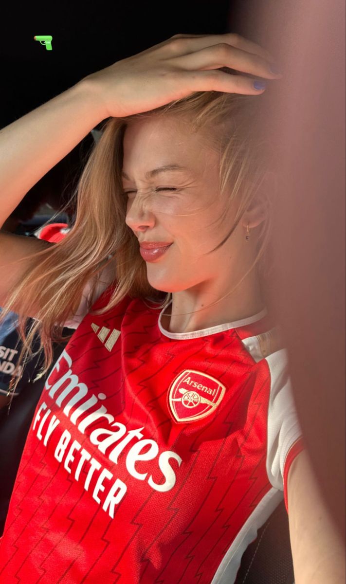 a woman in a red shirt holding her head