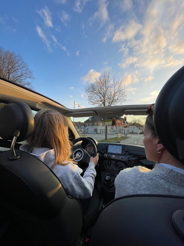 two people in a car driving down the road