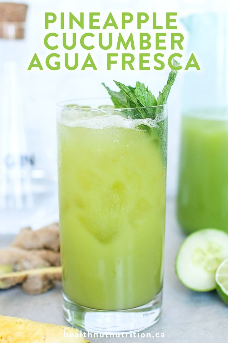 a glass filled with green liquid next to sliced cucumbers