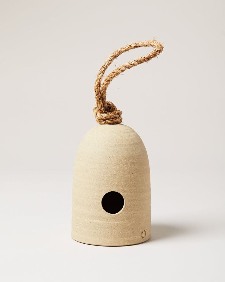 a wooden bell with a rope hanging from it's side on a white background