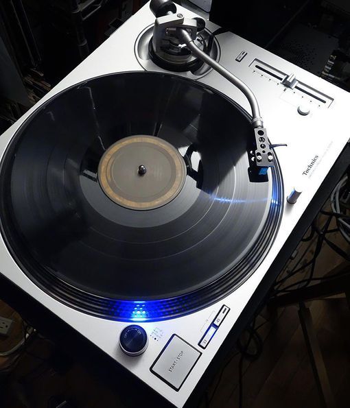 an old record player with its turntable turned on and blue light coming from it