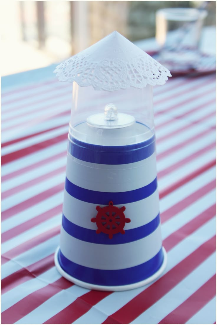 a blue and white striped table cloth with a small plastic container on top