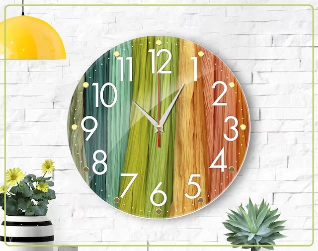 a colorful clock is on the wall next to a potted plant and a lamp