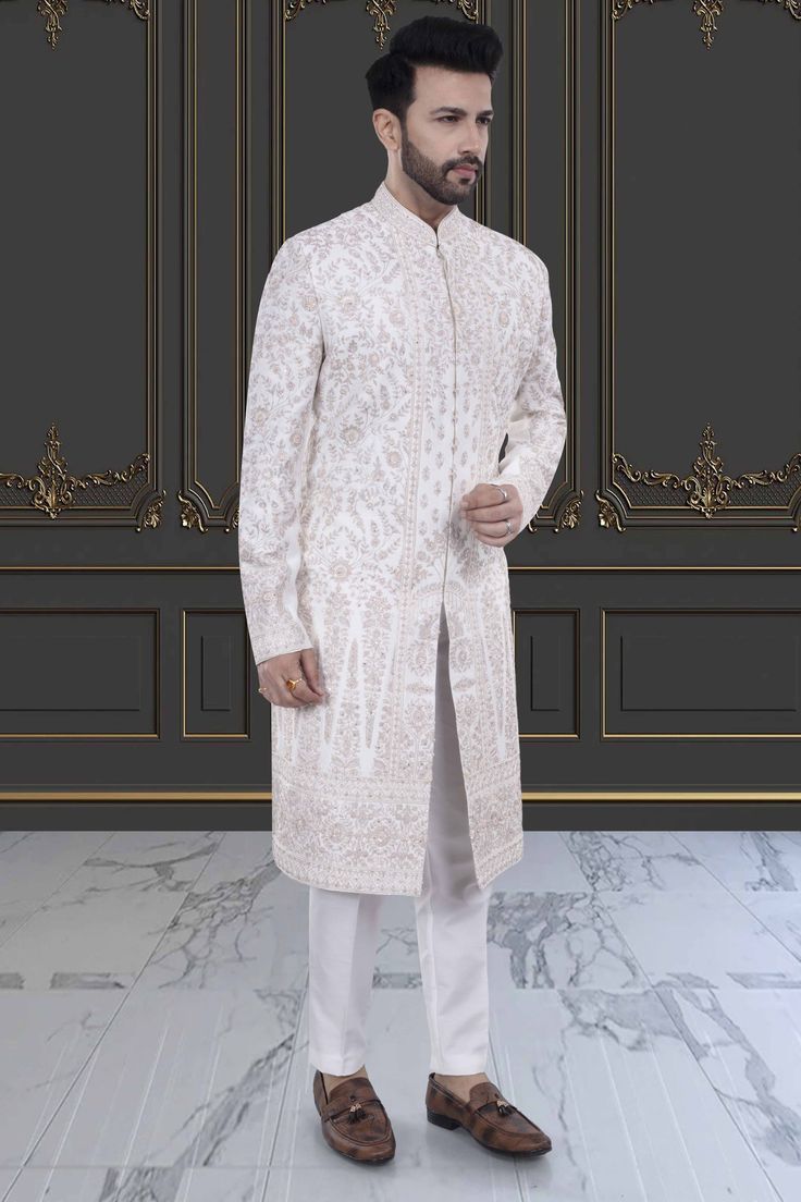 This impeccable sherwani, adorned with luxurious stones and intricate embroidery, exudes sophistication and elegance. Perfect for the stylish groom, it is a timeless masterpiece that will make a lasting impression. Indulge in the opulence and elevate your wedding day look with this R14-S71 sherwani. Wedding Sherwani With Chikankari Embroidery In Traditional Fit, Embroidered Traditional Fit Sherwani For Wedding, Elegant Traditional Fit Sherwani For Festive Occasions, Luxury Embroidered Sherwani For Formal Occasions, White Traditional Sherwani, Luxury Formal Sherwani With Intricate Embroidery, Traditional Fit Long Sleeve Sherwani For Wedding, Luxury Ceremonial Bandhgala With Intricate Embroidery, Traditional Fit Long Sleeve Wedding Sherwani