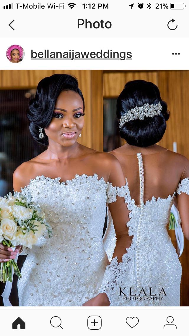 two women in wedding gowns standing next to each other and one is holding a bouquet