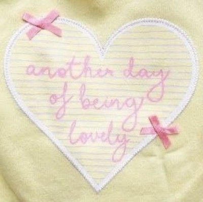 a white heart with pink writing on it that says, another day of being lovely