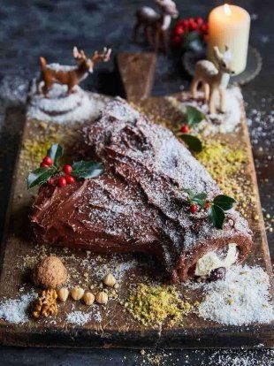 a large piece of chocolate cake on a wooden cutting board covered in powdered sugar and sprinkles