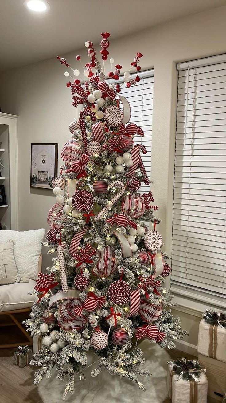 a christmas tree decorated with red, white and silver ornaments in the shape of candy canes