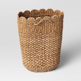 a large woven basket with handles on the bottom and sides, sitting in front of a white background