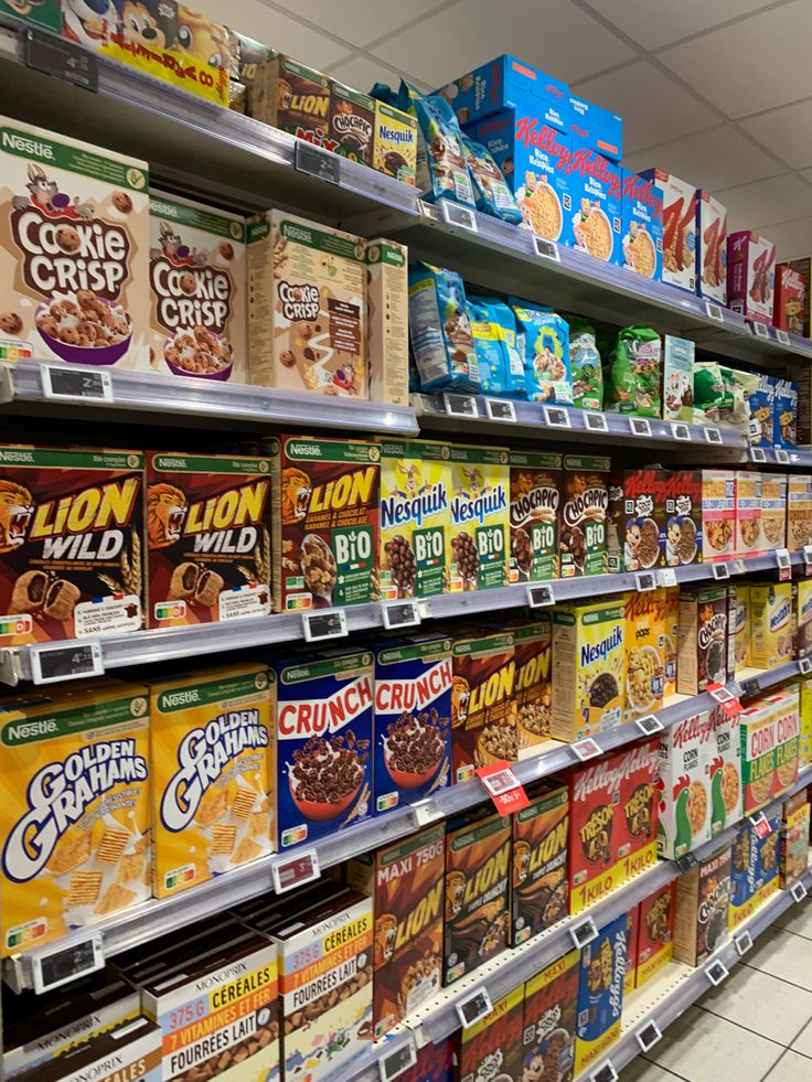 an aisle in a grocery store filled with cereals and cereal bars on display for sale