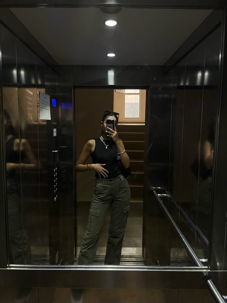 a man taking a selfie in an elevator while talking on his cell phone,