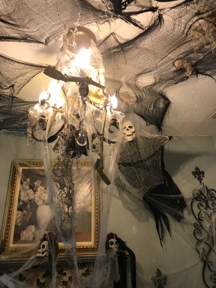 a chandelier with halloween decorations hanging from it's ceiling in a room